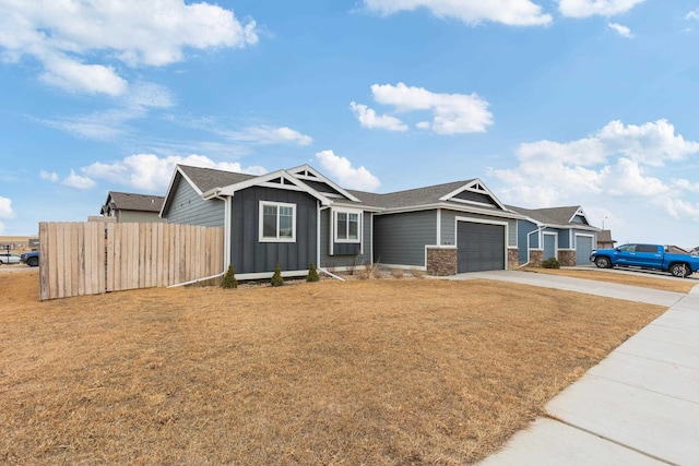 view of front of home featuring a front yard, fence, driveway, an attached garage, and board and batten siding