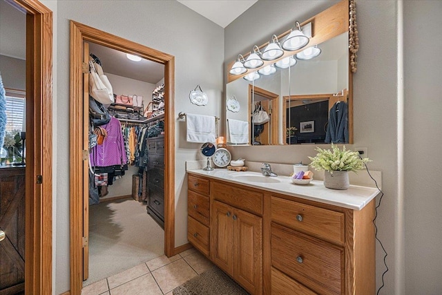 bathroom with vanity, tile patterned floors, and a walk in closet