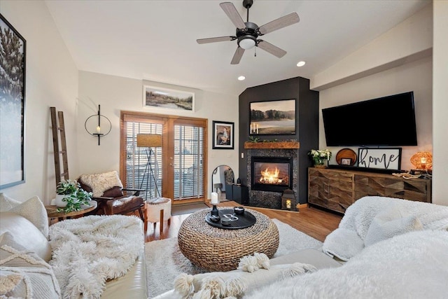 living room with ceiling fan, vaulted ceiling, recessed lighting, wood finished floors, and a glass covered fireplace