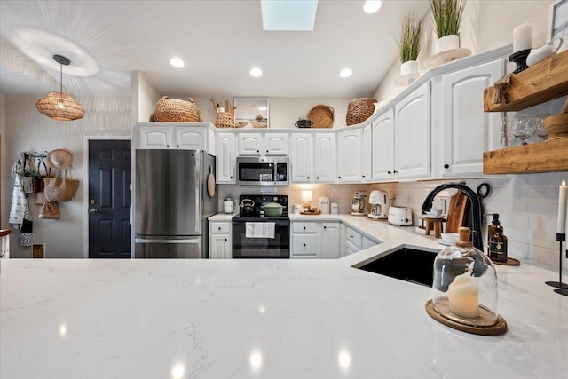 kitchen with a sink, open shelves, light stone counters, and stainless steel appliances