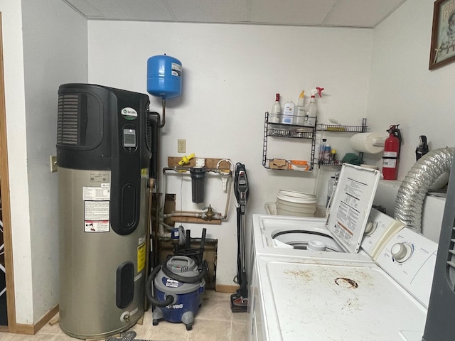 laundry room featuring tile patterned floors, washer and clothes dryer, baseboards, laundry area, and hybrid water heater