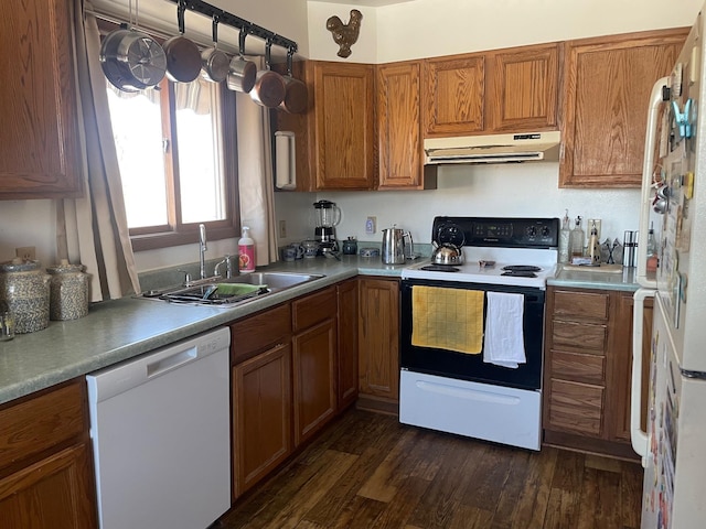 kitchen with under cabinet range hood, brown cabinets, electric stove, white dishwasher, and a sink