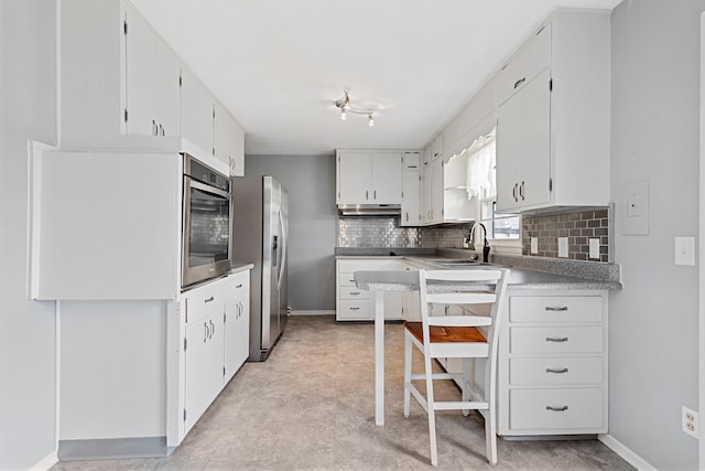 4320 Circle Dr, Rapid City, SD 57702 - kitchen featuring stainless steel refrigerator with ice dispenser, a sink, under cabinet range hood, tasteful backsplash, and baseboards
