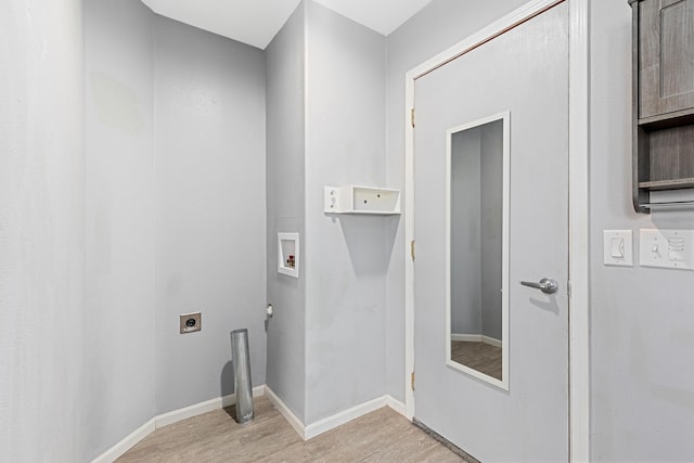 clothes washing area featuring hookup for a washing machine, baseboards, light wood finished floors, laundry area, and electric dryer hookup