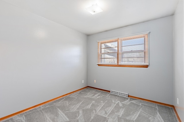 empty room with visible vents, baseboards, and carpet flooring