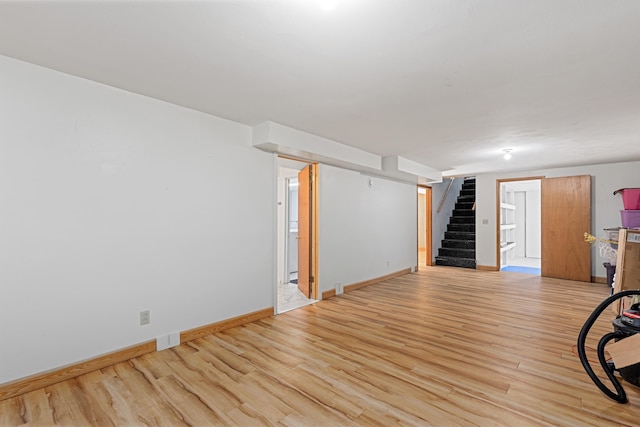 interior space with stairs, light wood-style flooring, and baseboards