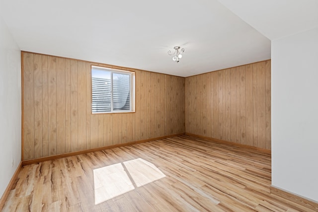 unfurnished room with baseboards and wood finished floors