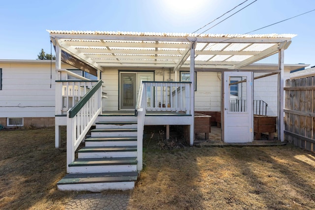 back of property featuring stairs, a pergola, and metal roof