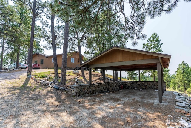 exterior space with a carport and dirt driveway