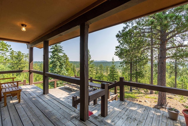 wooden deck with a wooded view