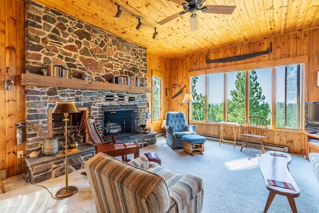 living room featuring a baseboard radiator, wooden walls, wooden ceiling, and a fireplace