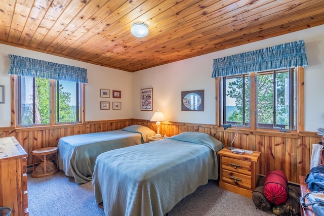 bedroom featuring wooden walls, carpet, wood ceiling, baseboard heating, and wainscoting