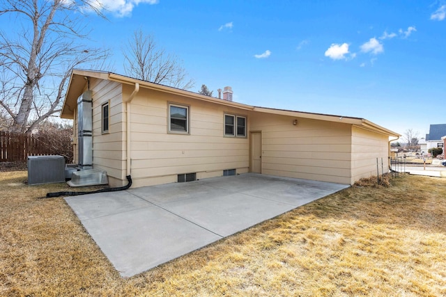 back of property with a yard, a patio, and fence