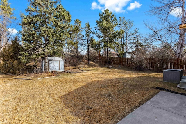 view of yard featuring a storage unit, an outdoor structure, and fence