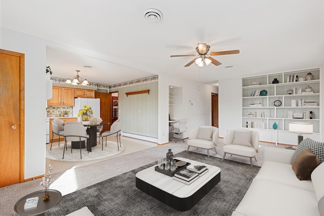 living area featuring visible vents, baseboard heating, and a ceiling fan