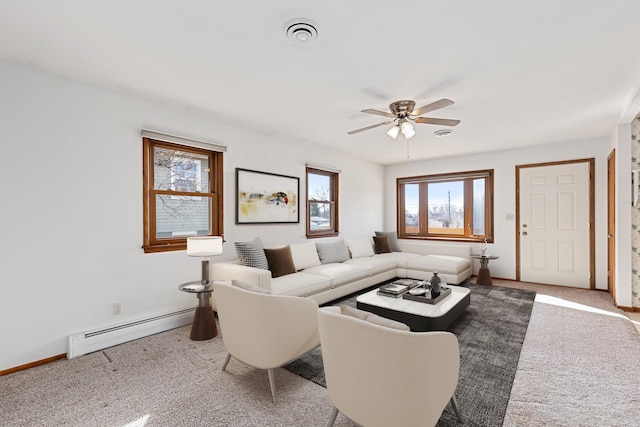 living area with visible vents, a ceiling fan, a baseboard heating unit, carpet floors, and baseboards