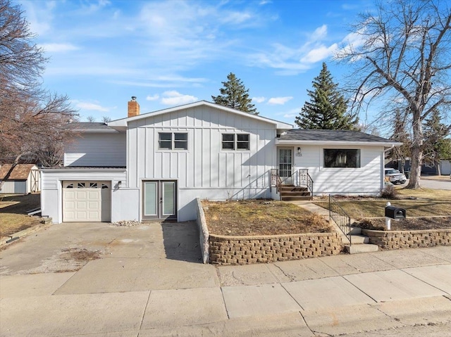 view of front of home with a garage, board and batten siding, concrete driveway, and a chimney