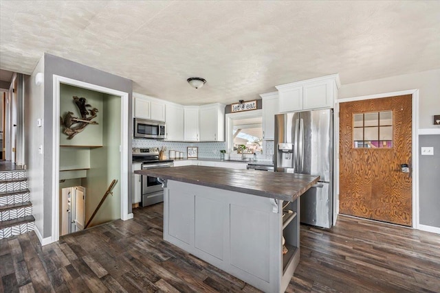 kitchen featuring dark wood-style floors, butcher block countertops, white cabinets, and stainless steel appliances