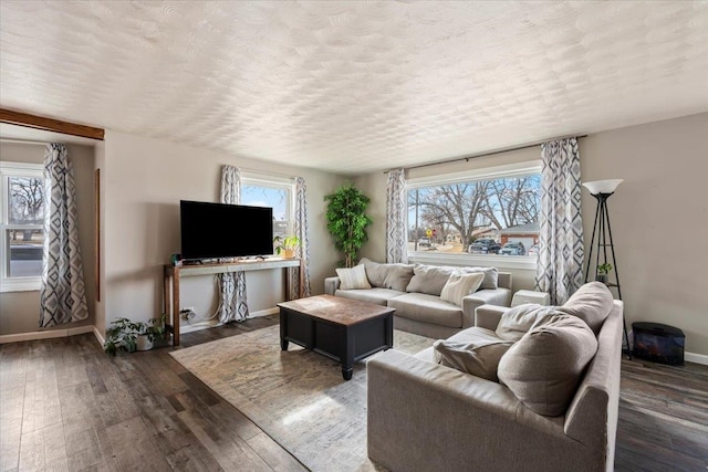 living area featuring baseboards, a textured ceiling, and dark wood finished floors