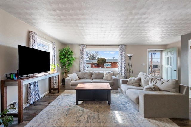 living room featuring baseboards, a textured ceiling, and wood finished floors