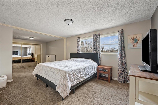 carpeted bedroom with a closet, a textured ceiling, and baseboards