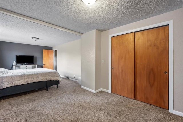 bedroom with carpet flooring, baseboards, a closet, and a textured ceiling