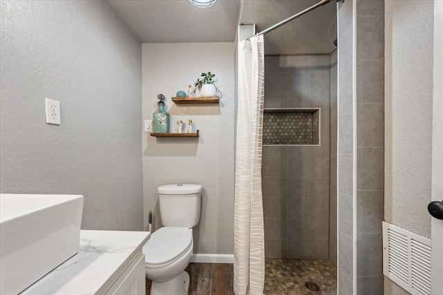 bathroom with visible vents, a shower stall, toilet, and wood finished floors