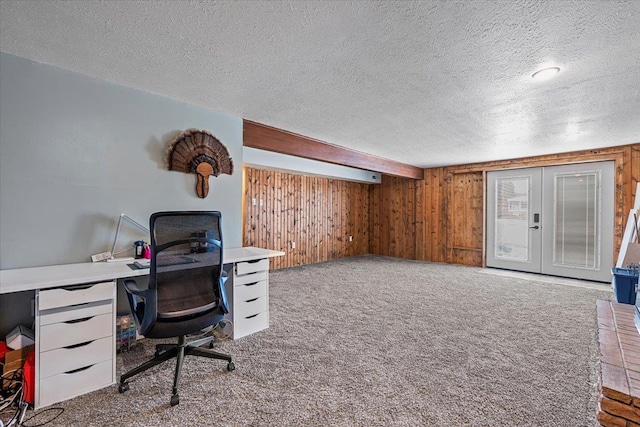 office area featuring wooden walls, carpet, french doors, and a textured ceiling