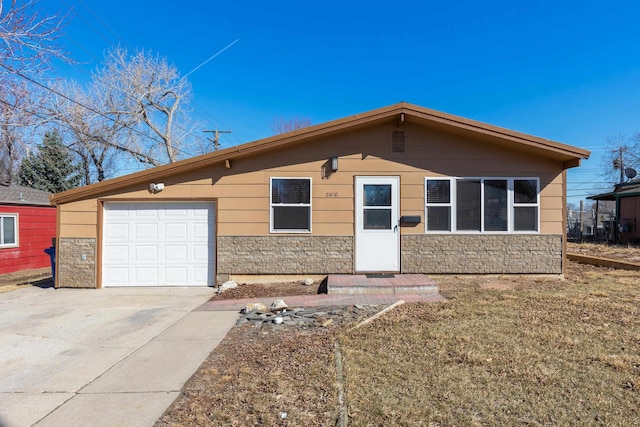 single story home featuring stone siding, an attached garage, and driveway