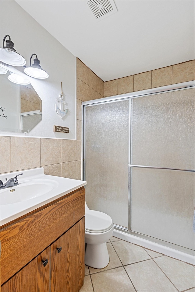 bathroom featuring visible vents, tile walls, a stall shower, and tile patterned flooring