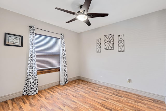 spare room with light wood finished floors, baseboards, and ceiling fan