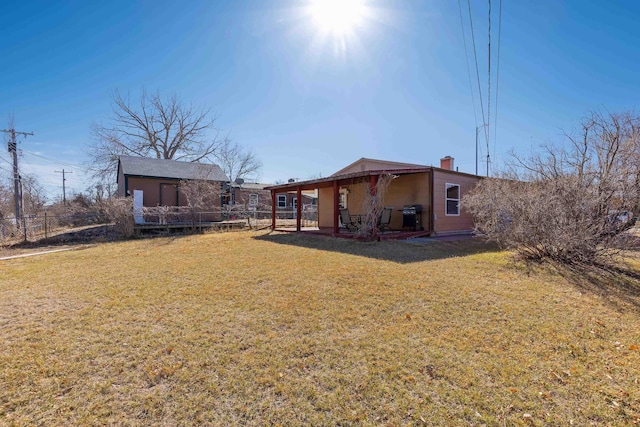 rear view of property featuring a yard and fence