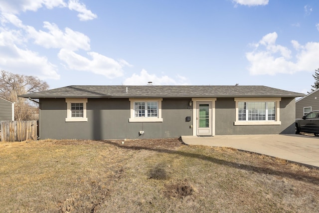 ranch-style house featuring a shingled roof, a patio area, fence, and stucco siding