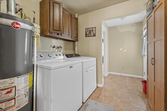 clothes washing area with baseboards, washing machine and dryer, gas water heater, light tile patterned floors, and cabinet space