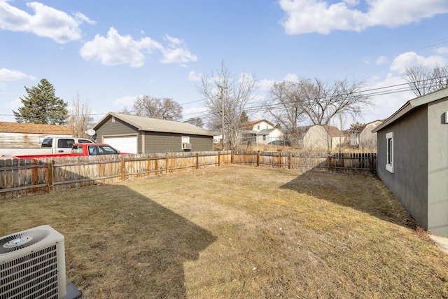 view of yard featuring central air condition unit, a detached garage, and a fenced backyard