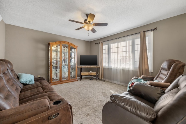 carpeted living room featuring baseboards, a textured ceiling, and ceiling fan