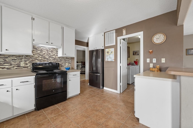 kitchen with black / electric stove, separate washer and dryer, freestanding refrigerator, decorative backsplash, and light countertops