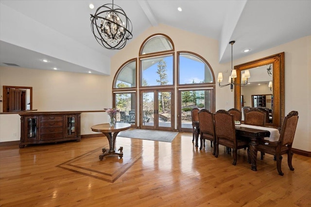 dining space with a chandelier, beam ceiling, high vaulted ceiling, and wood finished floors