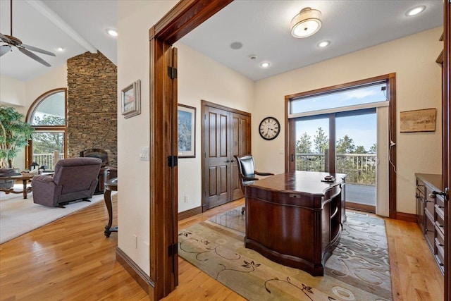 office space featuring baseboards, light wood-style floors, ceiling fan, and a fireplace