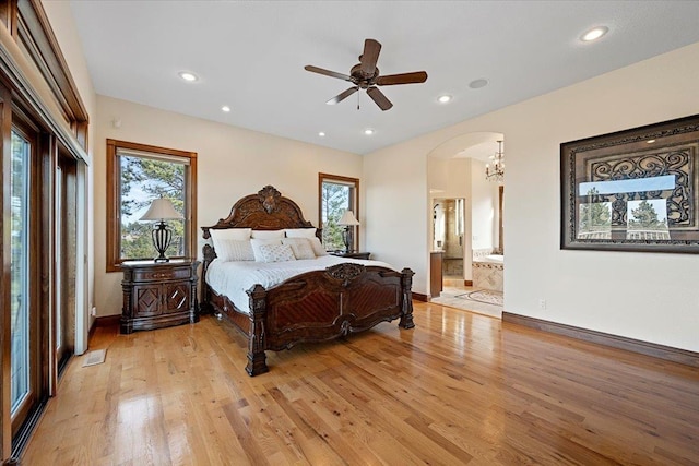 bedroom with recessed lighting, arched walkways, light wood finished floors, and baseboards