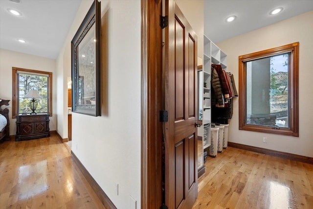 hallway with light wood-style flooring, recessed lighting, and baseboards