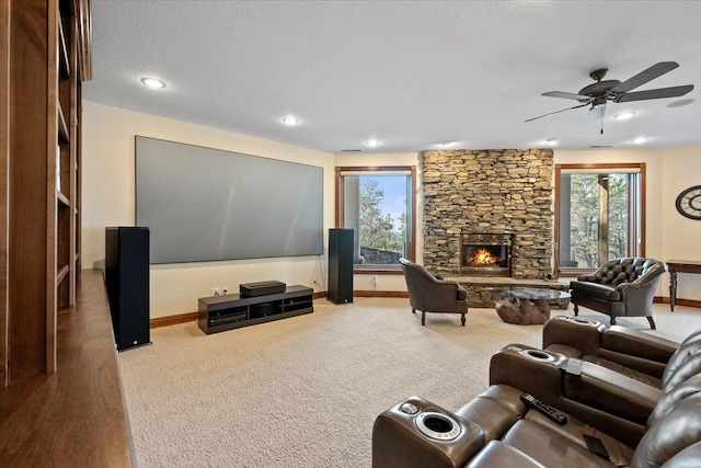 living room with a ceiling fan, a fireplace, baseboards, and carpet floors