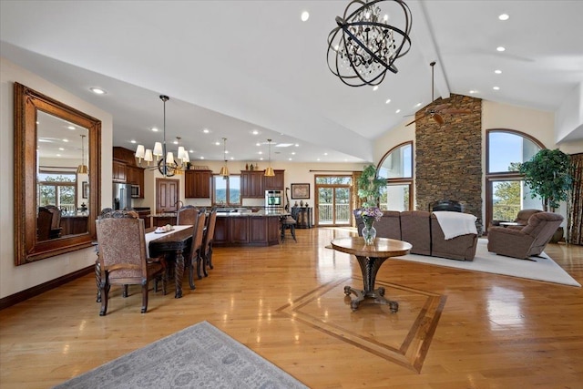 dining room featuring light wood finished floors, baseboards, recessed lighting, a notable chandelier, and high vaulted ceiling