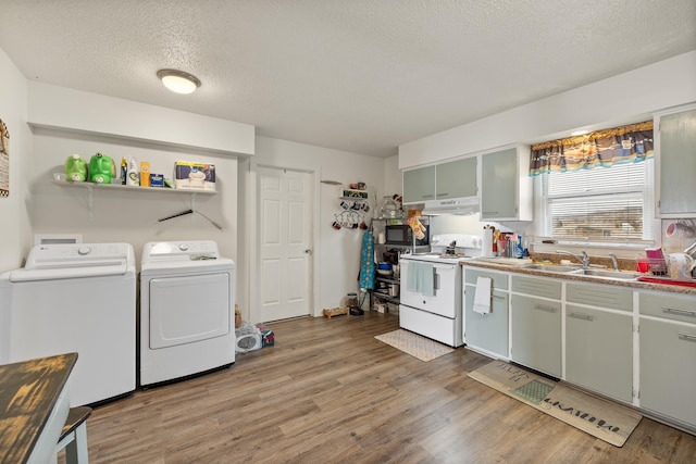 621 Other, Rapid City, SD 57701 - kitchen with white range with electric cooktop, a sink, under cabinet range hood, washing machine and dryer, and light wood finished floors