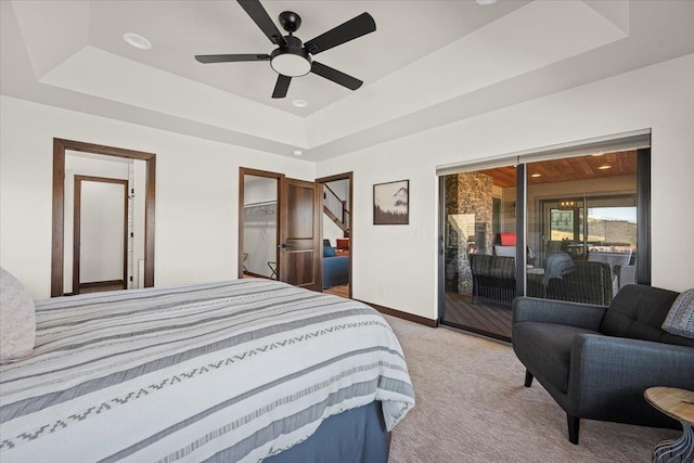 bedroom with baseboards, a tray ceiling, ceiling fan, access to exterior, and light colored carpet