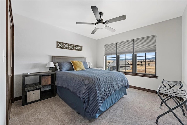 carpeted bedroom featuring baseboards and ceiling fan