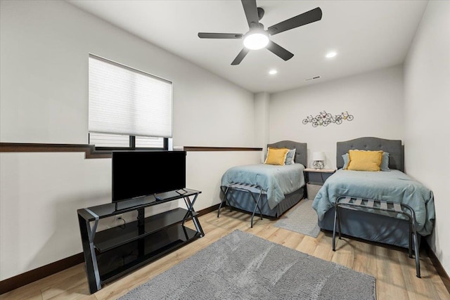 bedroom with visible vents, a ceiling fan, baseboards, and wood finished floors