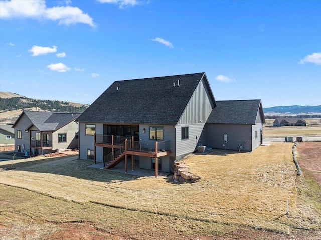 rear view of property featuring stairs, a deck with mountain view, board and batten siding, and a shingled roof