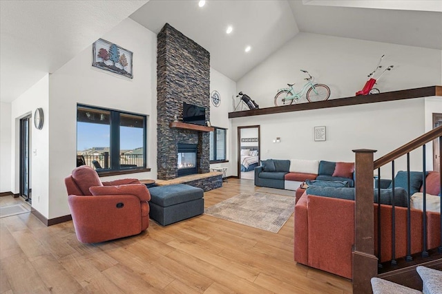 living area with high vaulted ceiling, wood finished floors, stairway, a fireplace, and baseboards