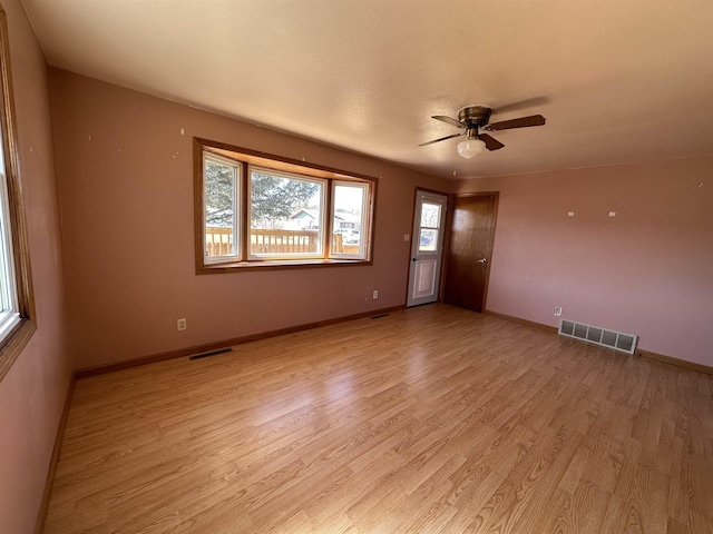 spare room with visible vents, baseboards, light wood-type flooring, and ceiling fan